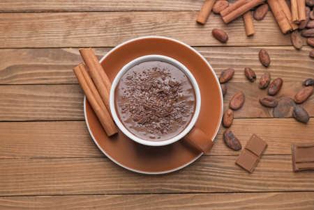 Cup of hot chocolate and cinnamon on wooden backgroundの写真素材