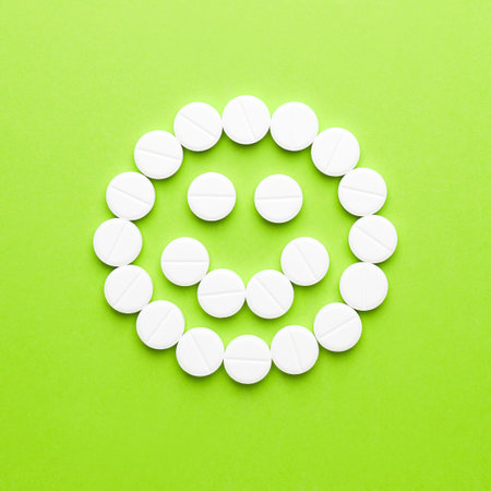 Happy face made of pills on color backgroundの写真素材