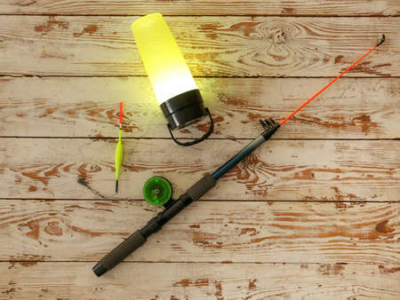 Modern flashlight with fishing rod on white wooden backgroundの写真素材