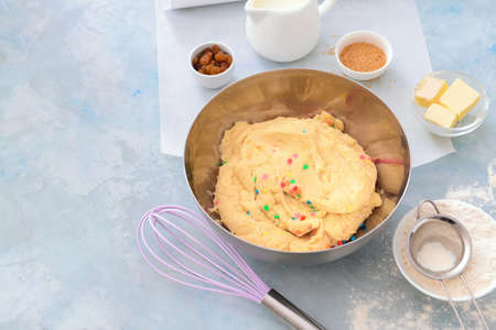Bowl with sweet dough and products on color backgroundの写真素材