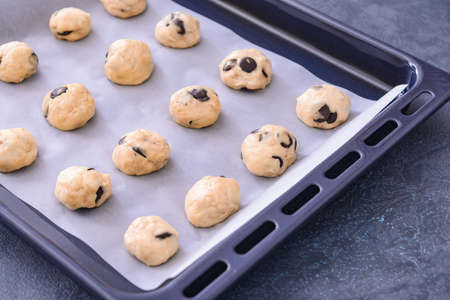 Baking tray with uncooked cookies on dark backgroundの写真素材