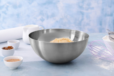 Bowl with sweet dough and products on color backgroundの写真素材