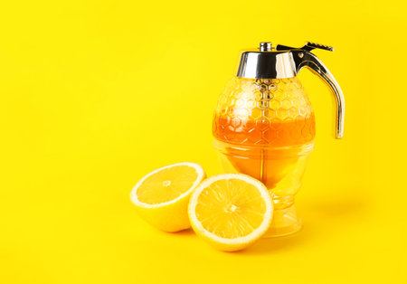 Pot of sweet honey and lemon on color backgroundの写真素材
