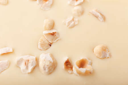 Sweet white chocolate with nuts as background, closeupの写真素材