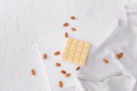 Sweet white chocolate with almond nuts on tableの写真素材