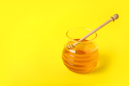 Jar of sweet honey on color backgroundの写真素材