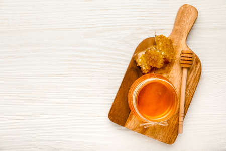 Jar of sweet honey, dipper and combs on wooden backgroundの写真素材