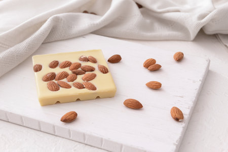 Sweet white chocolate with almond nuts on tableの写真素材