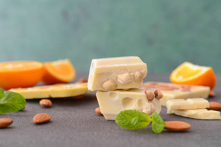Sweet white chocolate with nuts and orange on tableの写真素材