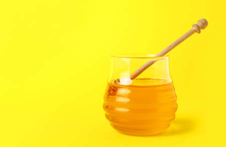 Jar of sweet honey on color backgroundの写真素材