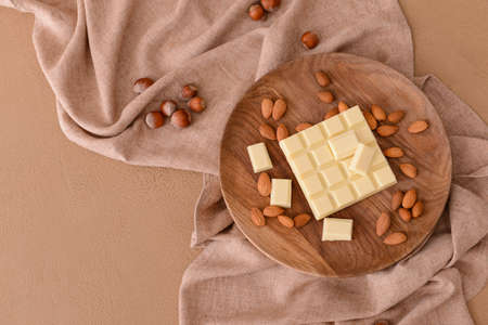 Plate with sweet white chocolate and almond on tableの写真素材