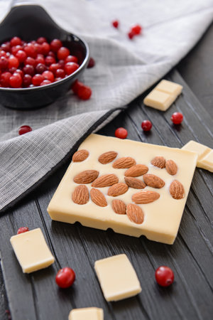 Sweet white chocolate with almond and cranberry on tableの写真素材