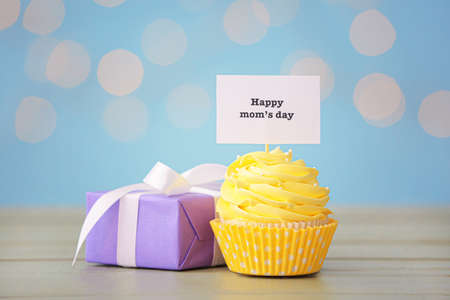 Tasty cupcake and gift for Mother's Day on tableの写真素材