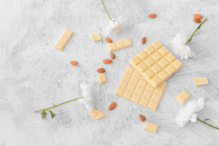 Sweet white chocolate with almond and flowers on tableの写真素材