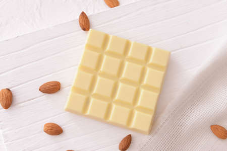 Sweet white chocolate with almond nuts on tableの写真素材