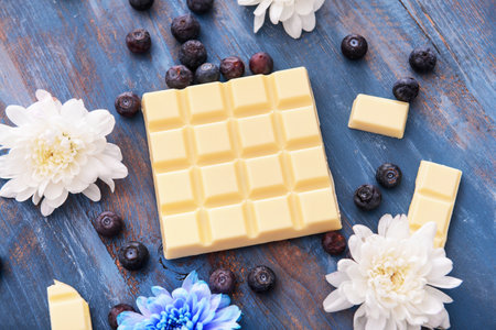 Sweet white chocolate with blueberry and flowers on tableの写真素材