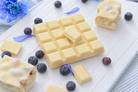 Sweet white chocolate with blueberry and flowers on tableの写真素材