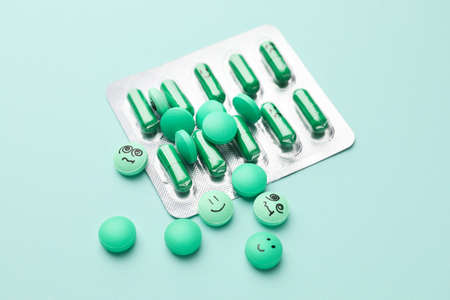 Blister pack and pills with different drawn faces on color backgroundの写真素材