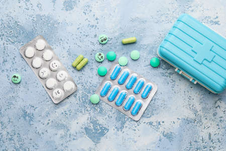 Pills with drawn faces on color backgroundの写真素材