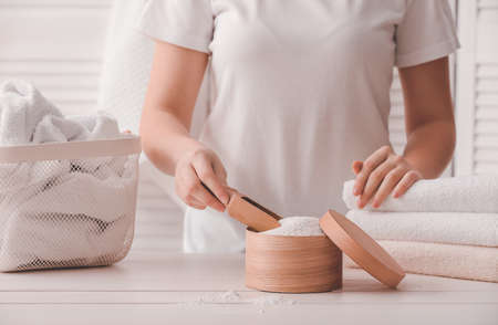 Woman with laundry detergent at home, closeupの写真素材
