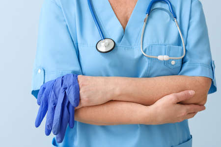 Mature female doctor on color backgroundの写真素材