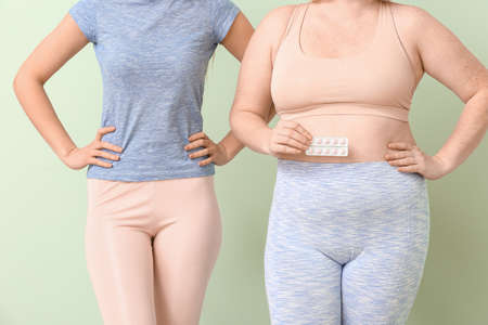 Women with weight loss pills on color backgroundの写真素材