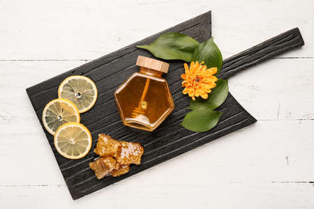 Jar of sweet honey with lemon on wooden backgroundの写真素材