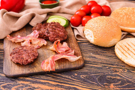 Ingredients for tasty burger on wooden tableの写真素材