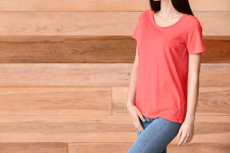 Woman in stylish t-shirt on wooden backgroundの写真素材