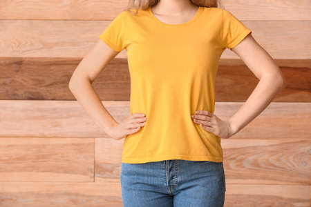 Woman in stylish t-shirt on wooden backgroundの写真素材