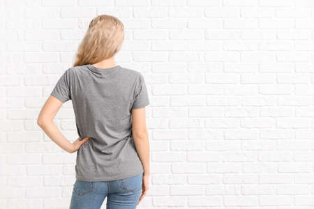 Woman in stylish t-shirt on white brick backgroundの写真素材