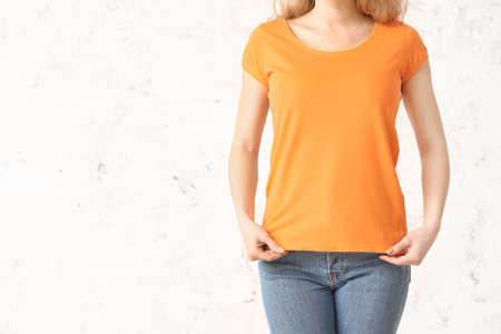 Woman in stylish t-shirt on light backgroundの写真素材