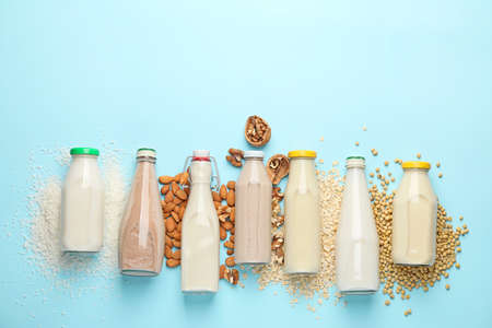 Bottles of different milk on color backgroundの写真素材