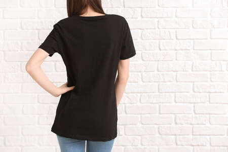 Woman in stylish t-shirt on white brick backgroundの写真素材