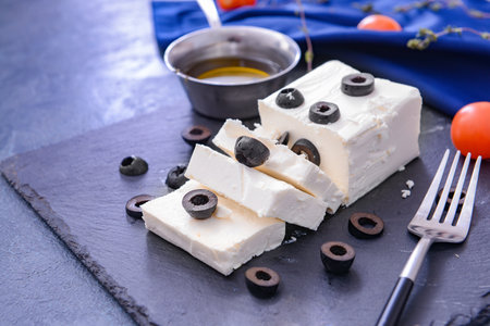 Tasty feta cheese with olives and oil on slate plateの写真素材