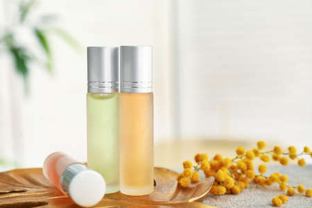 Roll-on perfumes and flowers on tableの写真素材