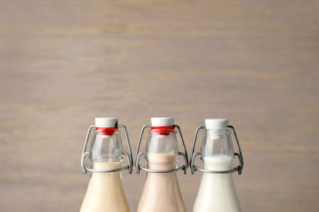 Bottles of different milk on wooden backgroundの写真素材