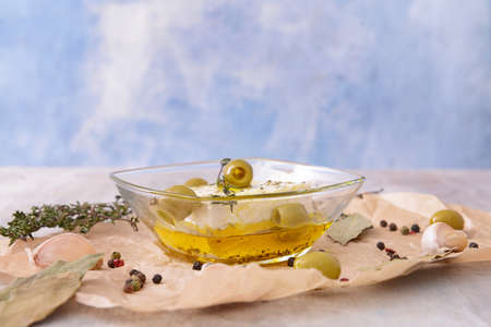 Tasty feta cheese with olives, oil and spices on tableの写真素材