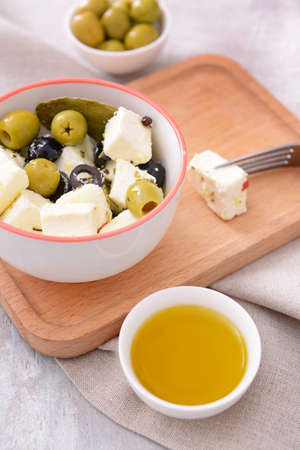 Tasty feta cheese with olives and oil on tableの写真素材