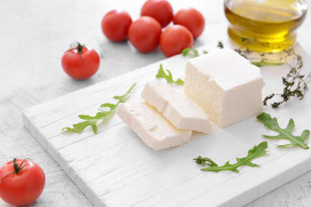 Tasty feta cheese with herbs on white backgroundの写真素材