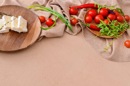 Tasty feta cheese with vegetables on color backgroundの写真素材