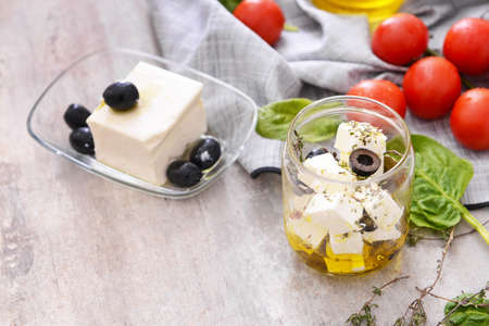 Tasty feta cheese with olives, oil and spices on gray backgroundの写真素材