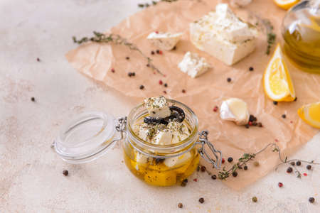 Jar with tasty feta cheese and oil on white backgroundの写真素材