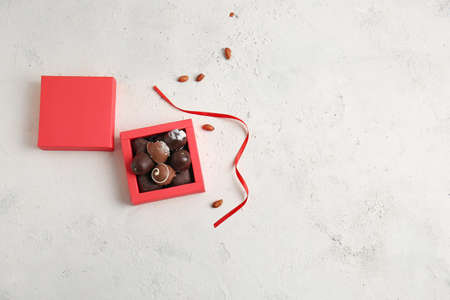 Box with delicious chocolate candies on light backgroundの写真素材