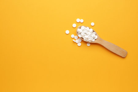 Spoon with pills on color backgroundの写真素材