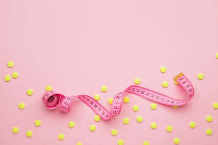 Measuring tape and weight loss pills on color backgroundの写真素材