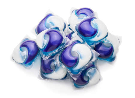 Capsules with laundry detergent on color background