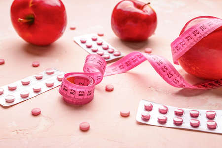 Measuring tape, apples and weight loss pills on color backgroundの写真素材