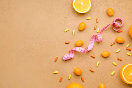 Measuring tape, fruits and weight loss pills on color backgroundの写真素材