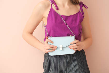 Beautiful woman with stylish bag on color backgroundの写真素材